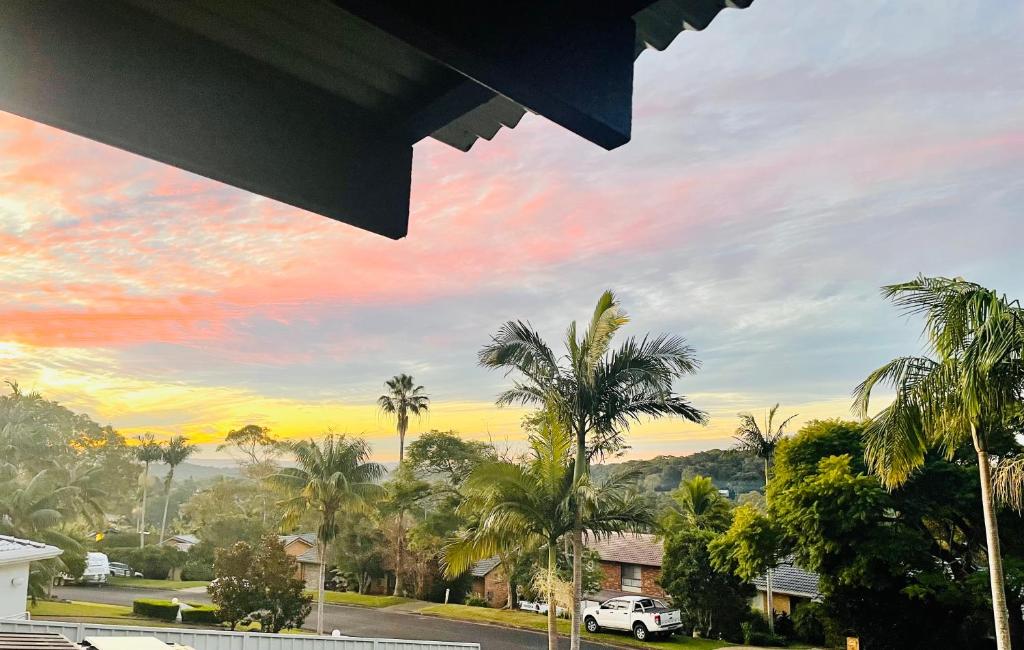 a view of a street with palm trees and a sunset at 5 OClock Somewhere 6BR sleeps 18 with Kids Retreat in Port Macquarie