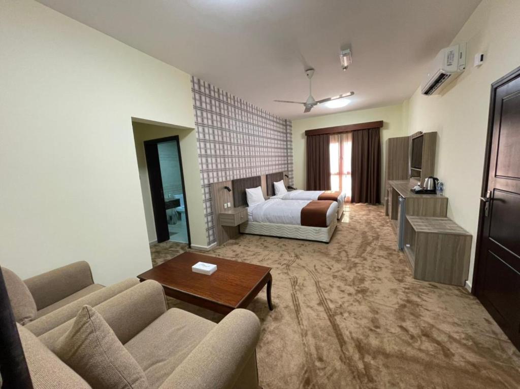 a hotel room with a bed and a living room at ROYAL HOTEL in Muscat