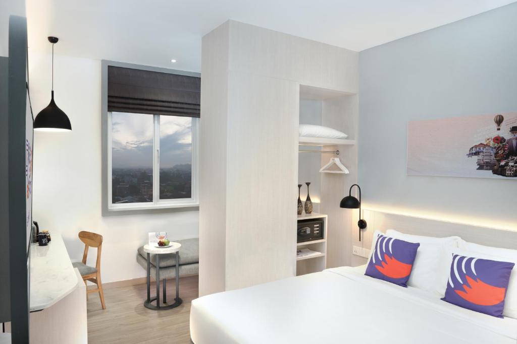 沙馬林達的住宿－FOX Lite Hotel Samarinda，一间卧室配有一张床、一张书桌和一个窗户。