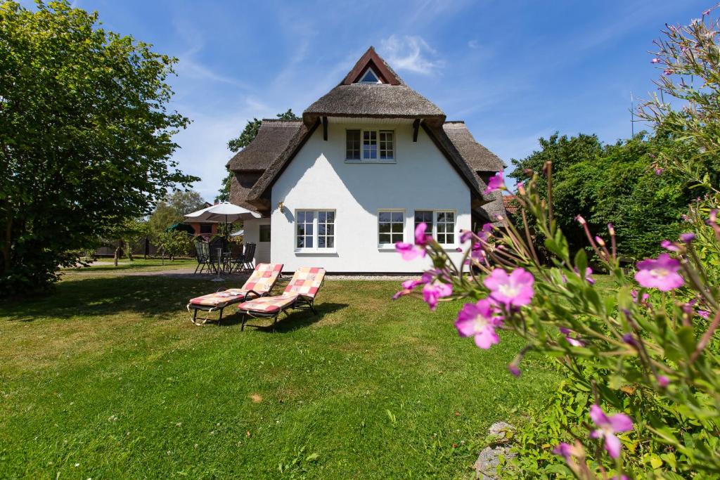 a group of chairs in front of a house at Künstlerhaus Rosenthal 02 in Ahrenshoop