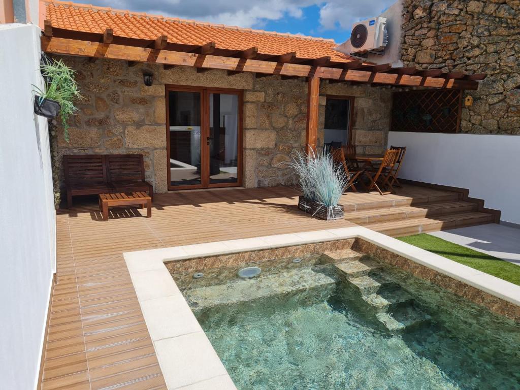 um pátio com uma piscina e uma casa em CASA DA CAPELA, Casas Bem Haja. em São Miguel de Acha