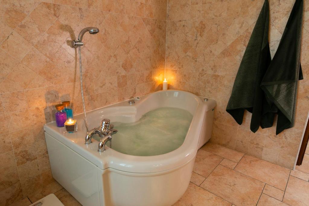 y baño con bañera y lavamanos. en Villa Mara - Aosta - 200 mq - WiFi - Jacuzzi - Parcheggio - Giardino, en Aosta