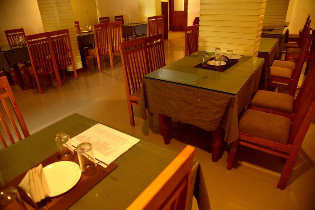 einen Blick über ein Restaurant mit Tischen und Stühlen in der Unterkunft Vyshak International in Payyannūr