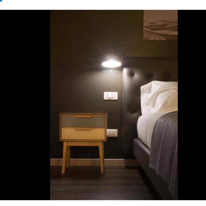 a bedroom with a bed and a nightstand with a light at Hotel B&B il Mosaico in Sirmione
