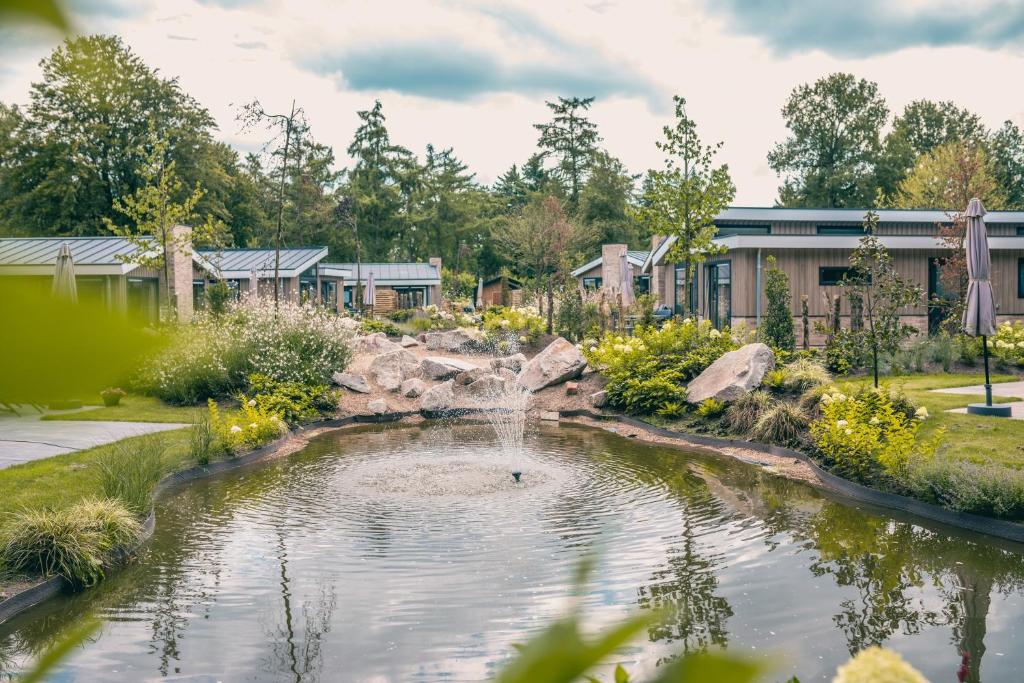 a pond in a garden with a waterfall at EuroParcs De Utrechtse Heuvelrug in Maarn