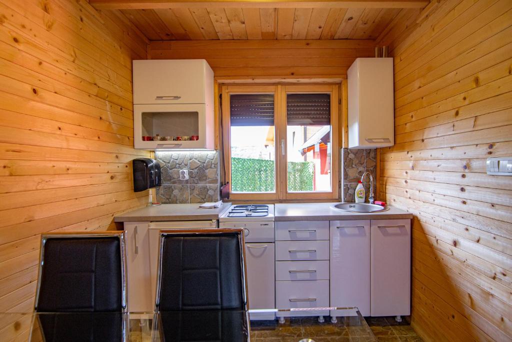 a kitchen in a wooden cabin with a sink at Zlatibor Brvnara Mir in Zlatibor