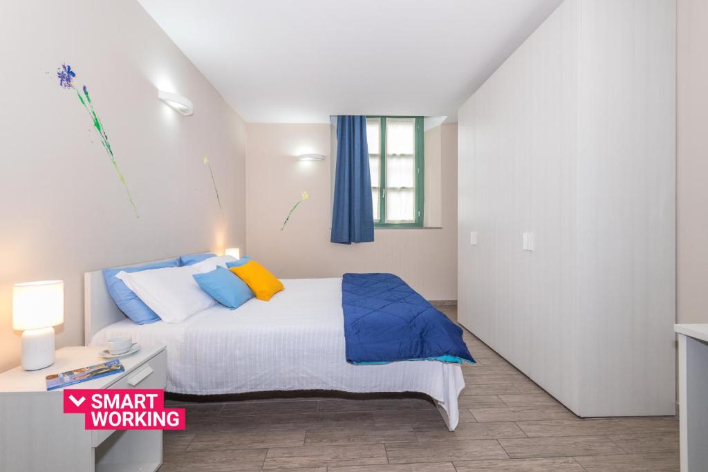 トリノにあるHousing Giuliaのベッドルーム1室(青と黄色の枕が備わるベッド1台付)