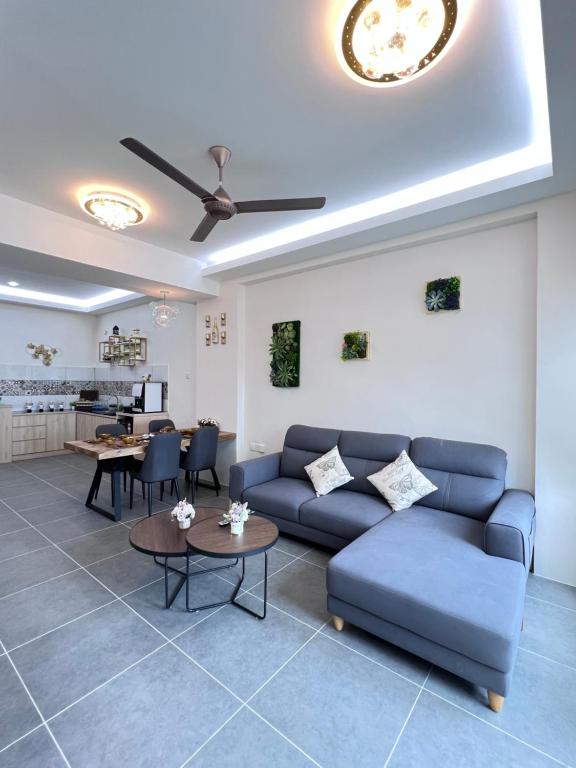 un salon avec un canapé bleu et des tables dans l'établissement 608 Ocean View 3 bedrooms, à Kuah