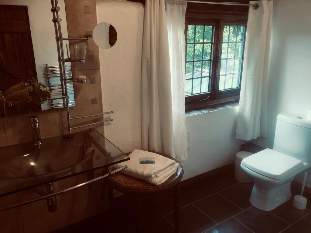 a bathroom with a glass tub and a toilet at Tudor House - Double Room - En suite in Goffs Oak