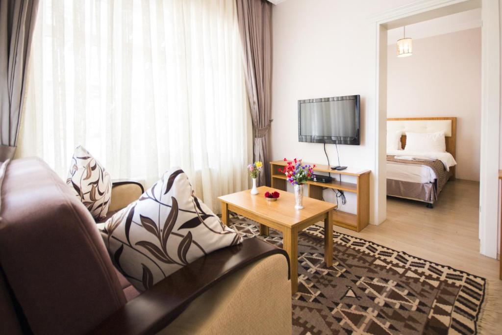 a hotel room with a couch and a bed and a television at Feyza Apart in Istanbul
