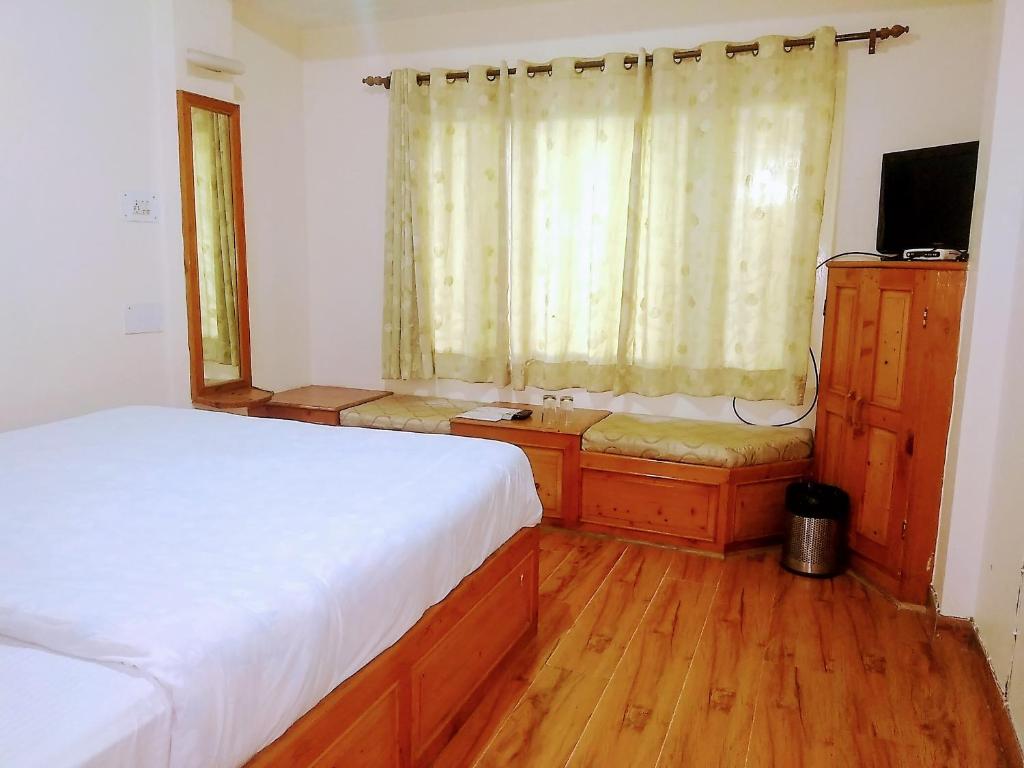 Postel nebo postele na pokoji v ubytování Hotel Rising Star Near To Mall Road #BudgetFriendly #BigRooms #Garden #Bonfire #Parking #ForestView #MountainView