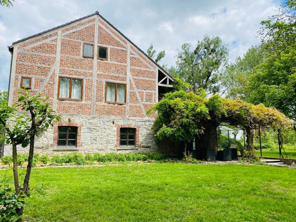una casa di mattoni con un prato verde davanti di Spacious house in Rochefort with private garden and terrace a Rochefort