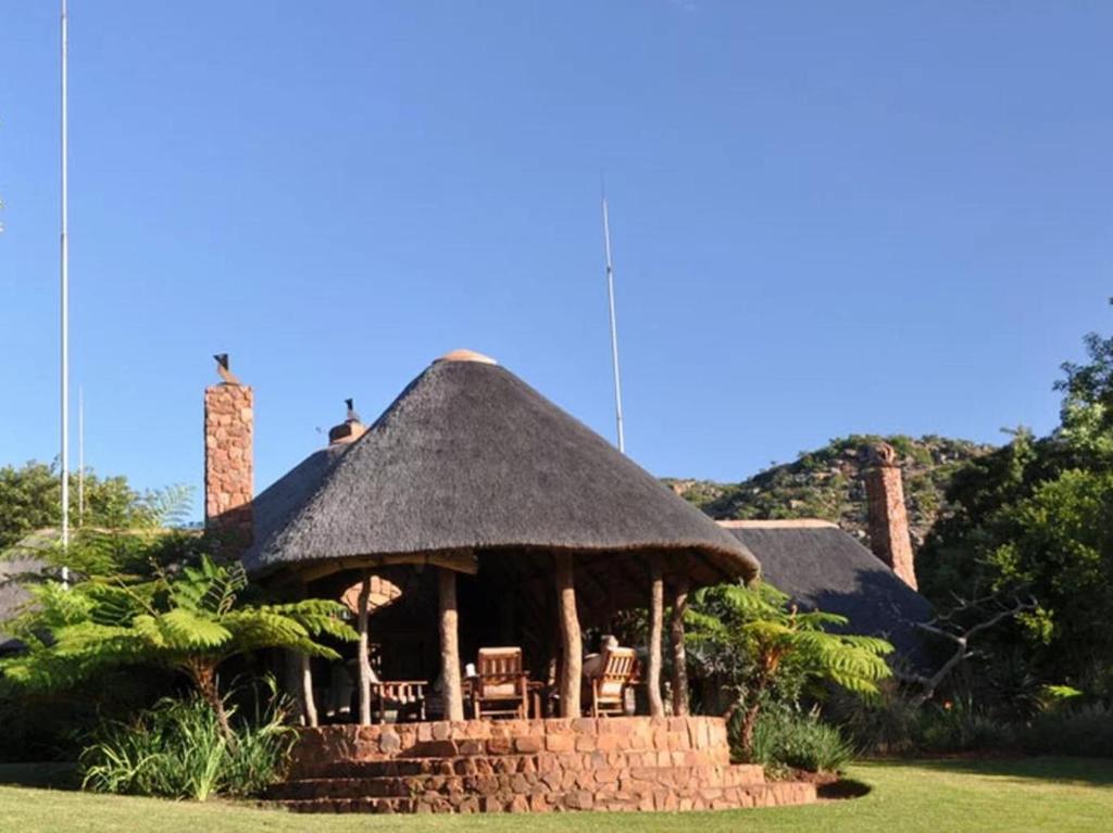 un pabellón con sillas y techo de hierba en Sigurwana Lodge, en Louis Trichardt