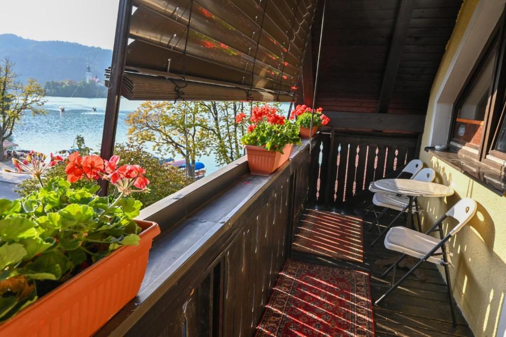 a balcony with potted plants and a view of the water at Apartment Maca Bled in Bled