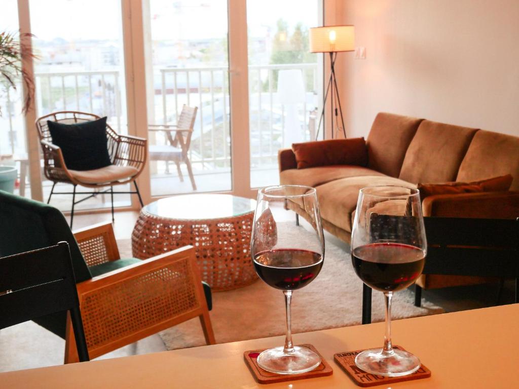 dos copas de vino sentadas en una mesa en una sala de estar en B&B : La Loggia Bastide, en Burdeos
