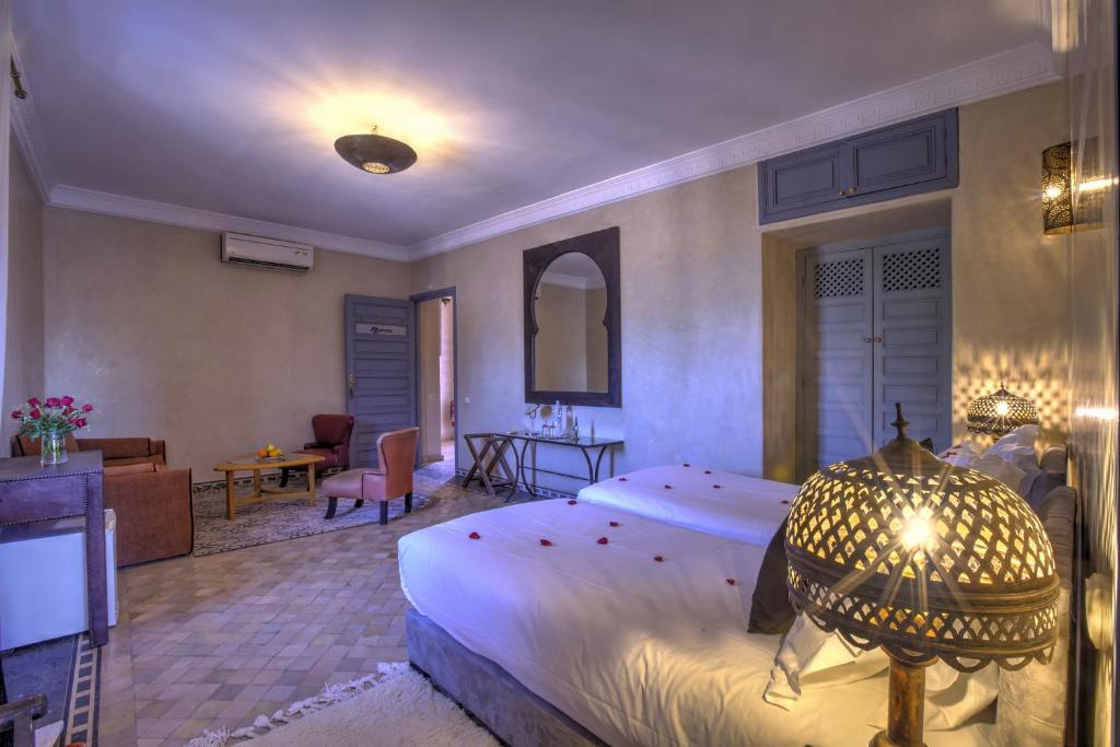 a bedroom with a large bed and a living room at Ksar Anika Boutique Hotel & Spa in Marrakech