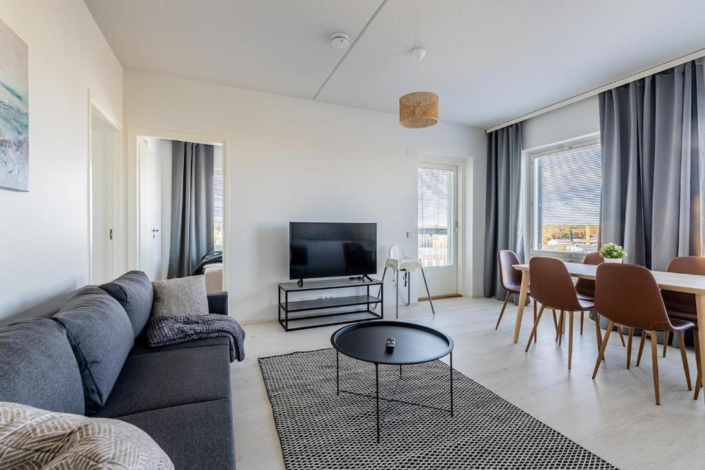 sala de estar con sofá y mesa en Apartment, SleepWell, Kirstinpuisto en Turku