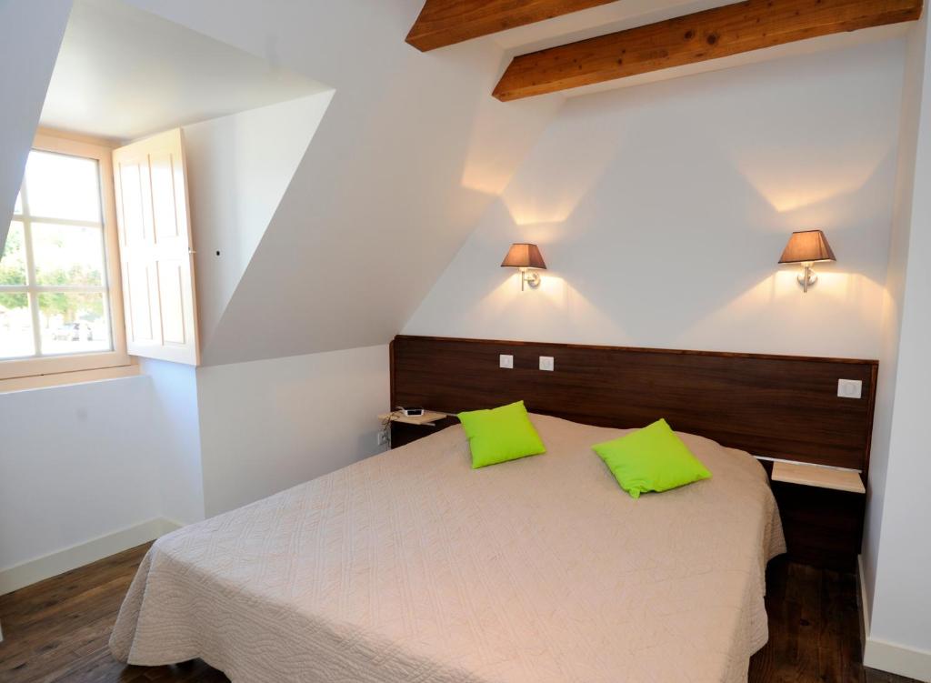 1 dormitorio con 1 cama con 2 almohadas de color verde lima en Le Clos des Rives, en Saint-Vincent-de-Cosse