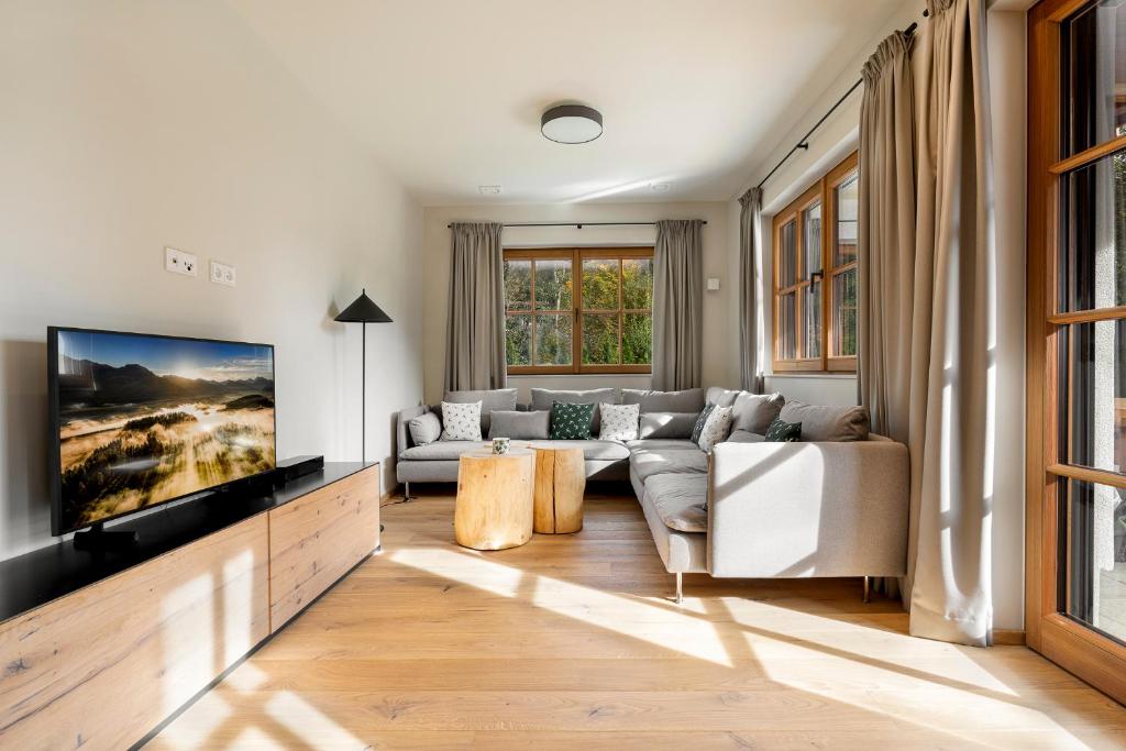 sala de estar con sofá y TV en Garten Suite Kirchberg by Alpine Host Helpers, en Kirchberg in Tirol