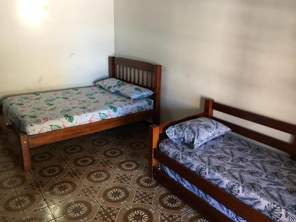 2 camas en una habitación con suelo en Linda casa com piscina de frente para Praia Grande em Arraial do Cabo-Rj, en Arraial do Cabo