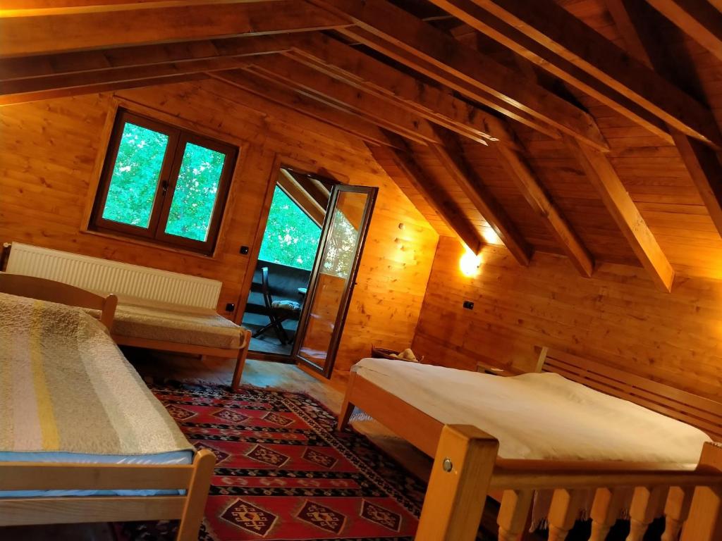 um quarto com duas camas e janelas num camarote em Kuća u šumi - Forest house near National park Una - Air Spa Lohovo em Bihać