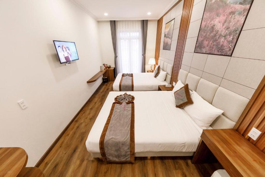 Giường trong phòng chung tại Wisteria Hotel