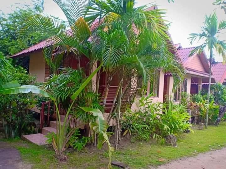 a house with palm trees in front of it at Apache Bar Haad yao in Haad Yao