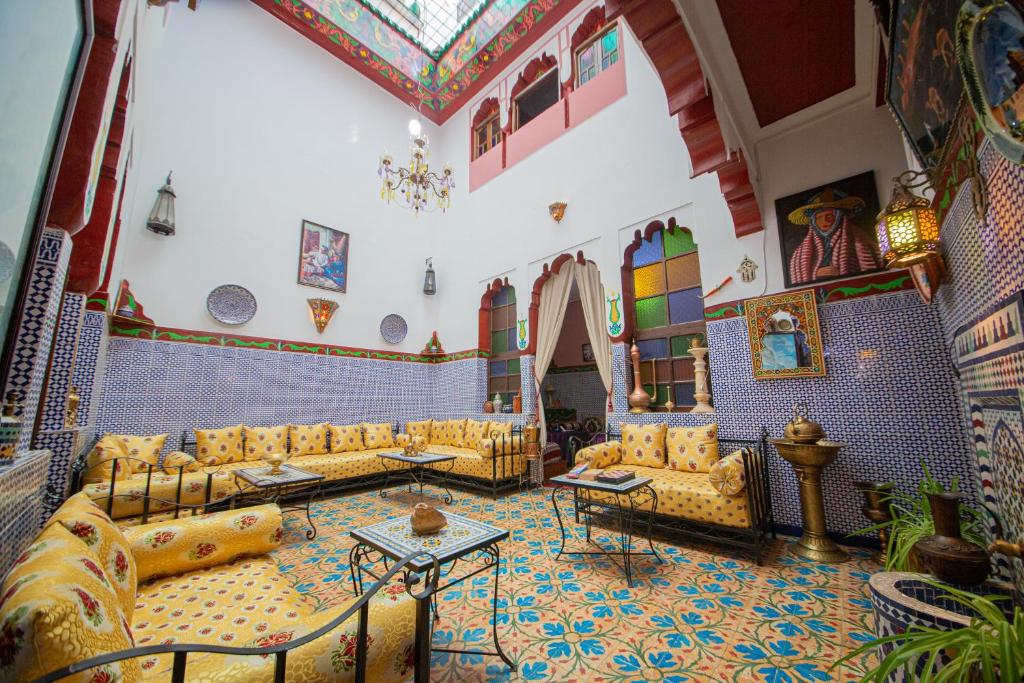uma grande sala com sofás e mesas num edifício em Maison Adam em Fez
