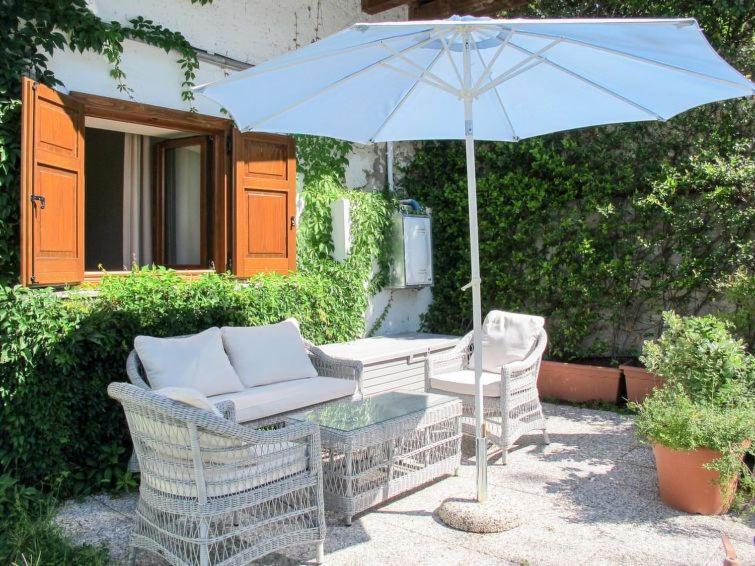 - une table avec un parasol bleu, des chaises et une table avec dans l'établissement cottage lavanda e rosmarino, à Lavis