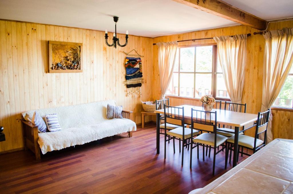 sala de estar con mesa y sofá en Casa Pehuen, Cabañas, en Villarrica