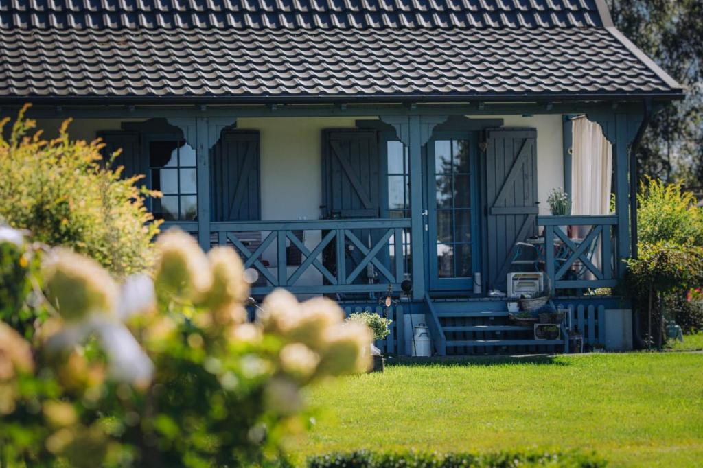 a house with a blue and white porch at Niebieski Domek in Kamień Pomorski