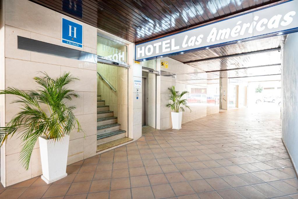 a hotel entrance with two potted plants in a hallway at Hotel Las Américas in Málaga