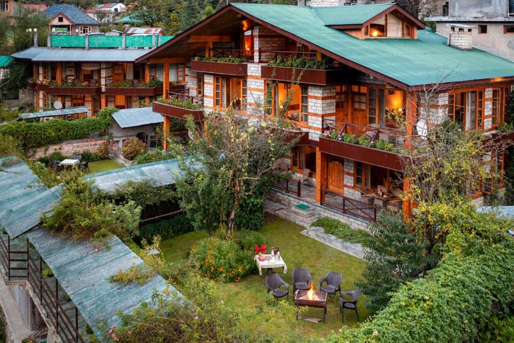 StayVista at Himalayan Retreat في مانالي: اطلالة جوية على منزل مع حديقة