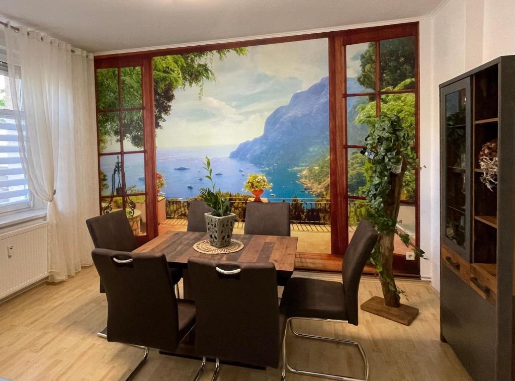uma sala de jantar com uma grande pintura na parede em Moderne 3 Raum Altbau ETW bis 4 Gäste, Nähe Staatstheater, Parkplatz, Netflix, Vollausstattung em Cottbus