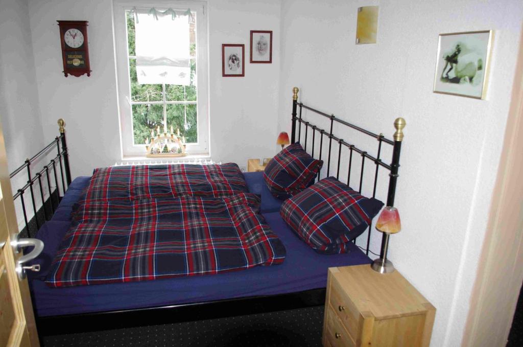 - une chambre avec un lit bleu et une couverture tressée dans l'établissement Ferienwohnung Sonneneck, à Wernigerode