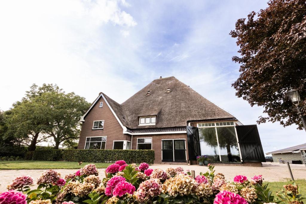 a house with a pointed roof with flowers in front at de Zuiderstolp in Zuidermeer