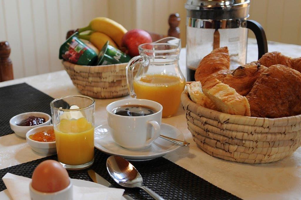a breakfast table with baskets of bread and orange juice at Glamping at Camping La Source in Saint-Pierre-dʼArgençon
