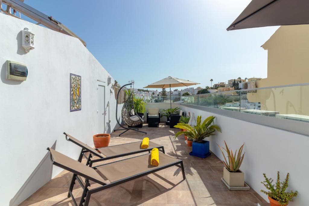 a balcony with a table and chairs on a building at Casa Angelica in Praia do Carvoeiro