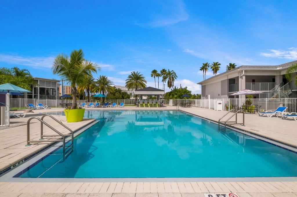 una piscina en un complejo con palmeras en Clarion Inn & Suites Across From Universal Orlando Resort en Orlando