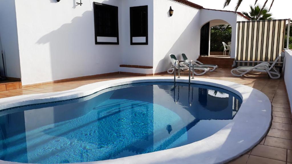 a swimming pool in front of a house at La Quinta Villas in San Miguel de Abona