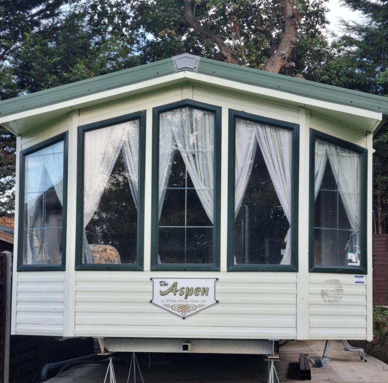 eine weiß abgeschirmte Veranda mit Vorhängen darauf in der Unterkunft Quite 3 Bedroom Static Caravan in Sidcup