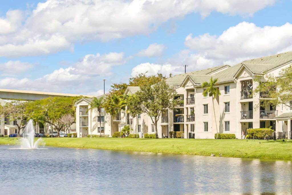 an exterior view of a building with a pond and a fountain at Stunning Centrally Located Apartments at New River Cove in South Florida in Fort Lauderdale