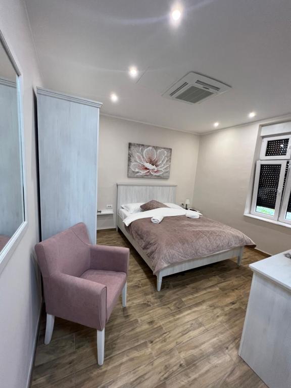 a bedroom with a bed and a chair at Story Lux Apartments in Belgrade