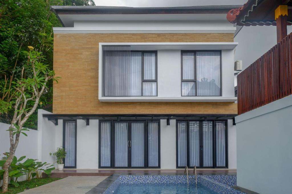 een huis met een zwembad ervoor bij The Lavana Greenkhaza Villa Jogja in Yogyakarta