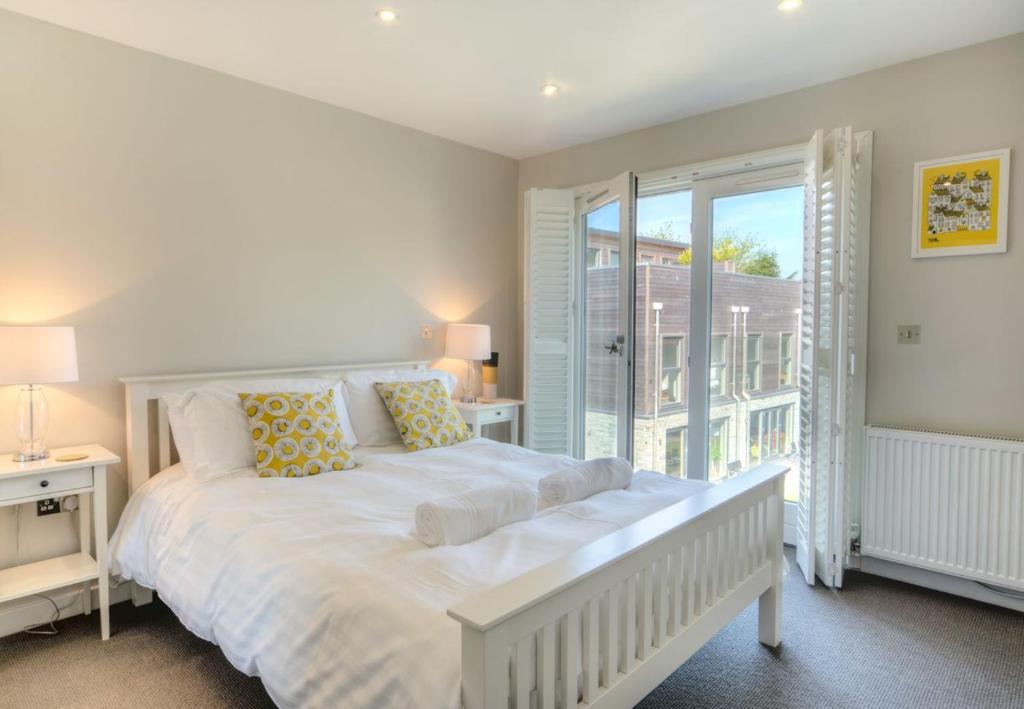 Un dormitorio blanco con una cama grande y una ventana en House 11, en Looe