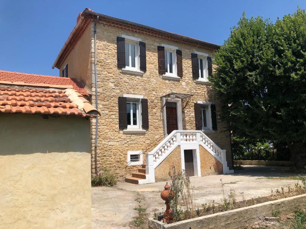 a large brick house with a white staircase in front of it at L&#39;Ardeche en Provence avec jardin ombragé in Pont-Saint-Esprit