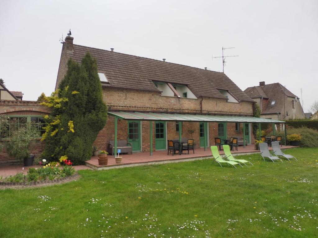 uma casa com um quintal com cadeiras e um pátio em The Green House em Kolczewo