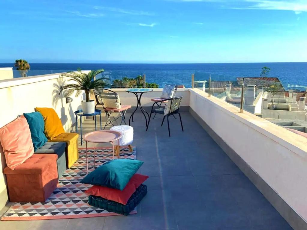 a balcony with chairs and tables and a view of the ocean at Casa puerto Isla Plana - Grande in Isla Plana