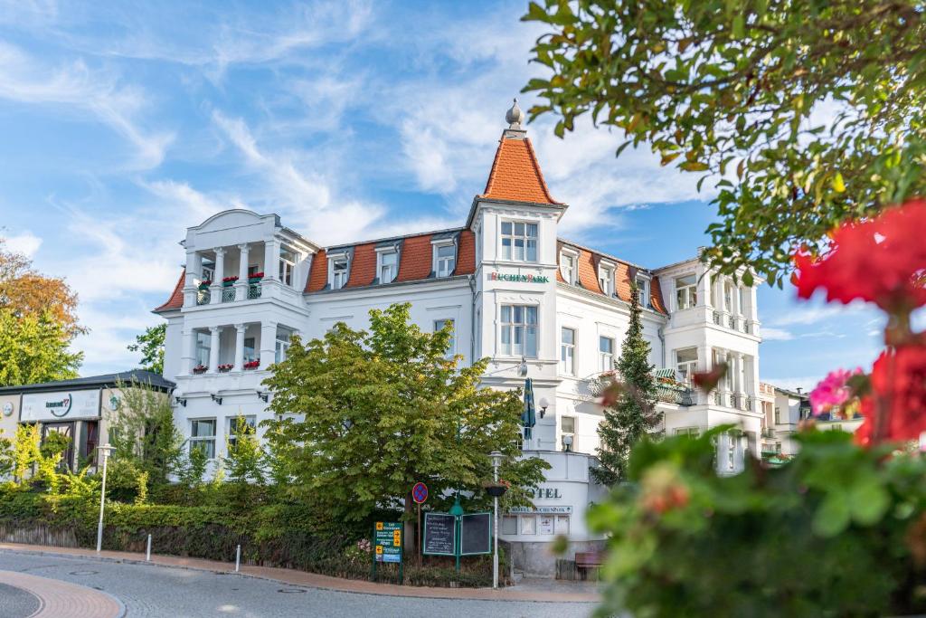 ein großes weißes Gebäude mit orangefarbenem Dach in der Unterkunft Hotel Buchenpark in Bansin