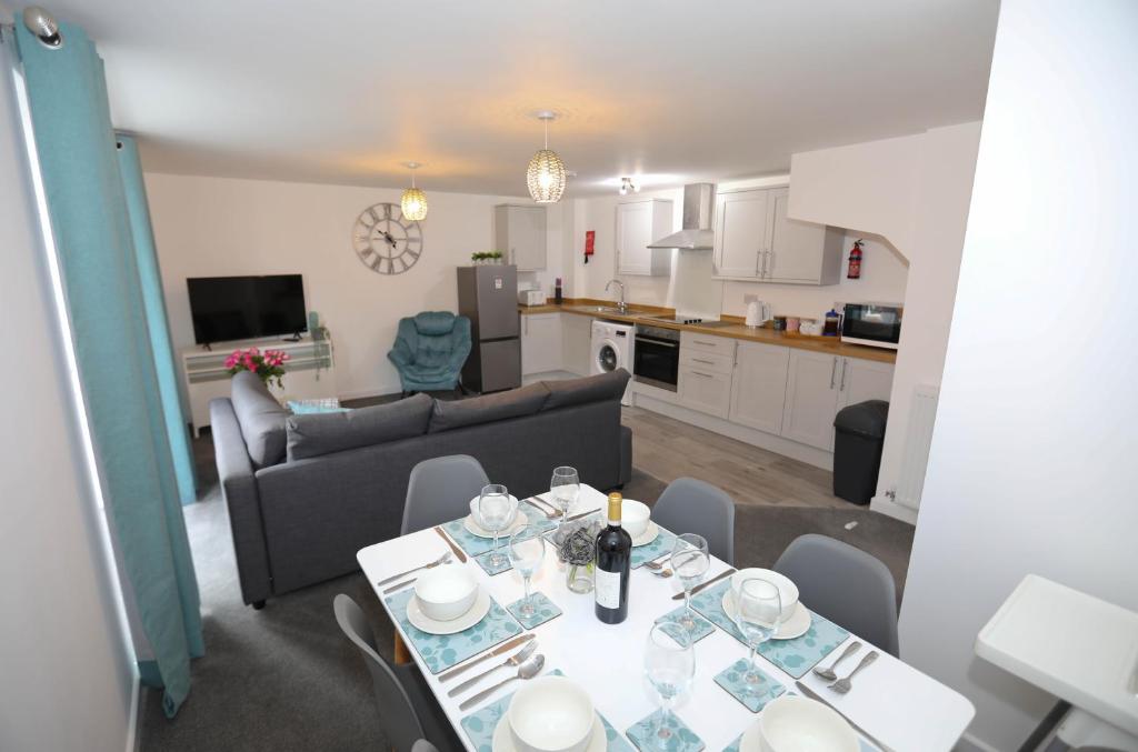 a living room and kitchen with a table and chairs at Strand House Flat 2 Free Parking, by RentMyHouse in Exmouth